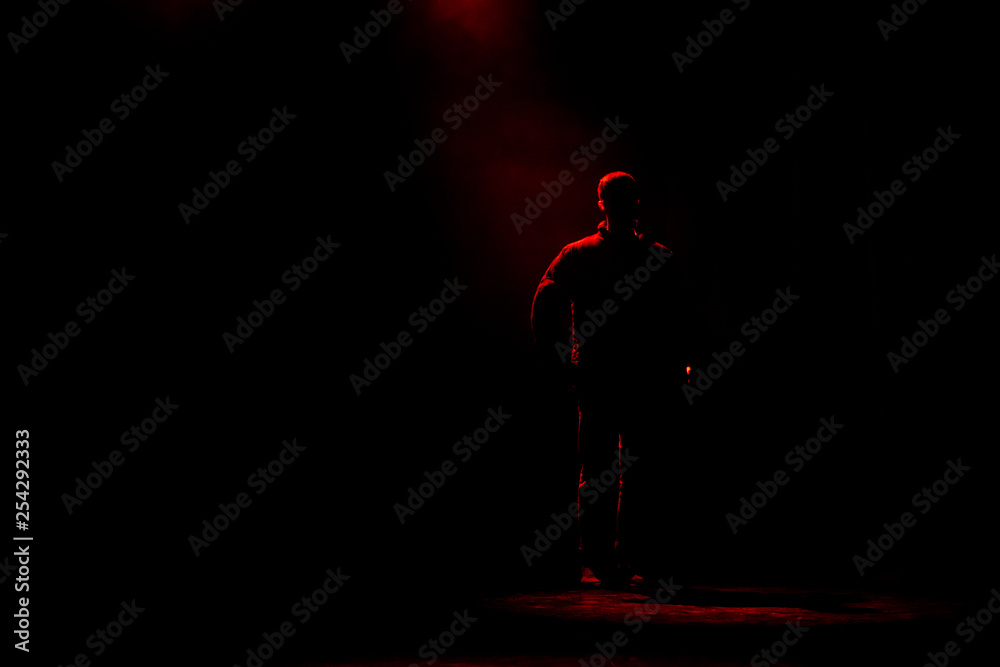 Man standing in the red dark