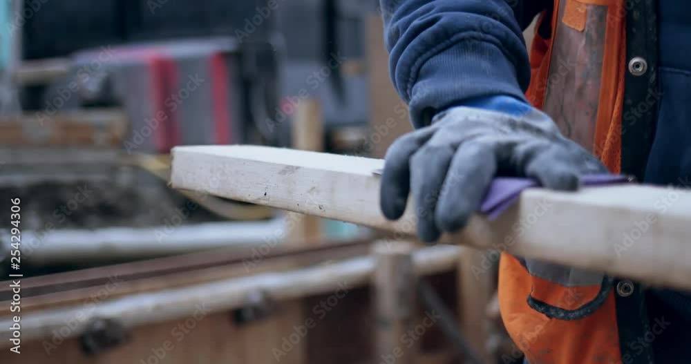 Close up of construction worker sanding wood outside on construction site 4k 59.94fps