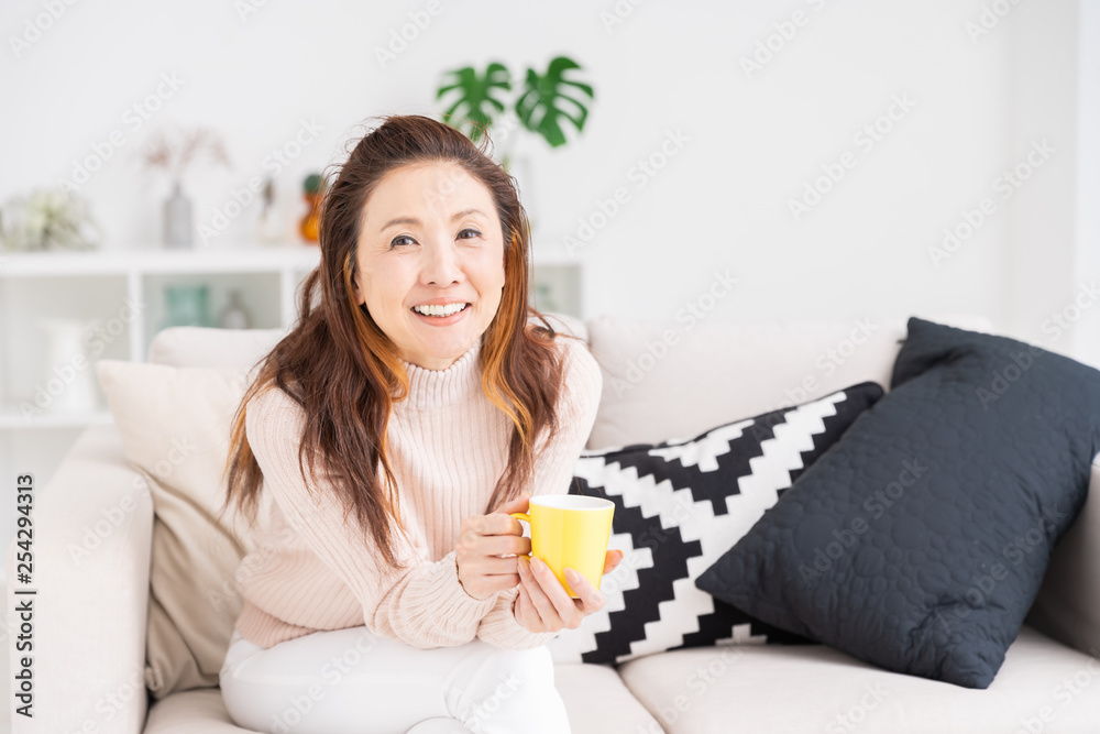 部屋でリラックスするシニア女性　飲み物