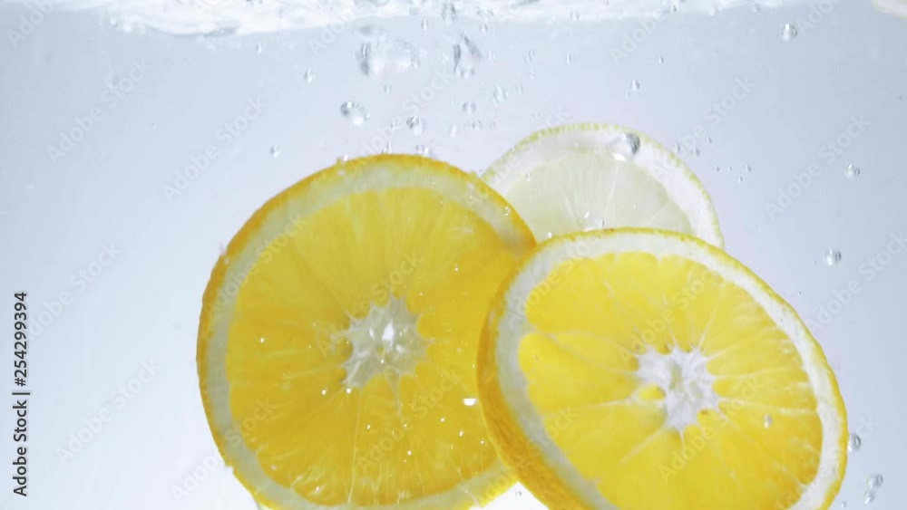 Close up shot of lemon slices falling into water Close up shot of lemon slices falling into water