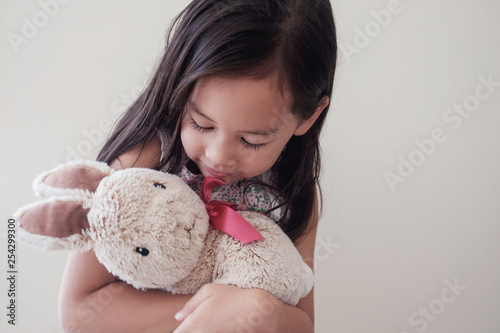 Happy little multicultural asiann girl with bunny rabbit, Easter kid