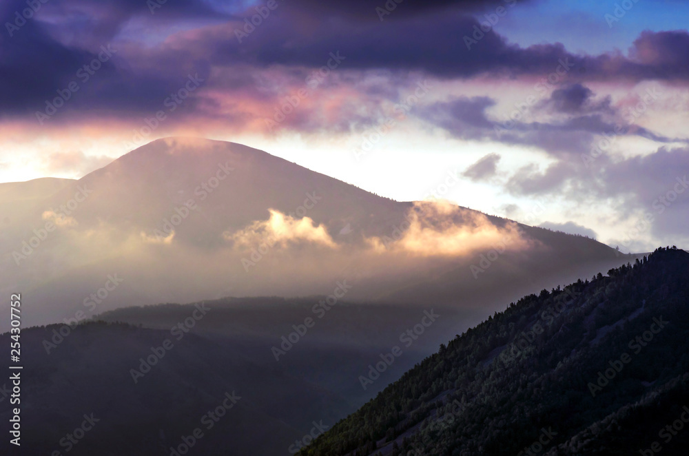Dramatic Sunrise in the Mountains with Cloudy Sky and Misty Forest, Altai Mountains, East Kazakhstan. Fantasyland, Blue Hour Concept.