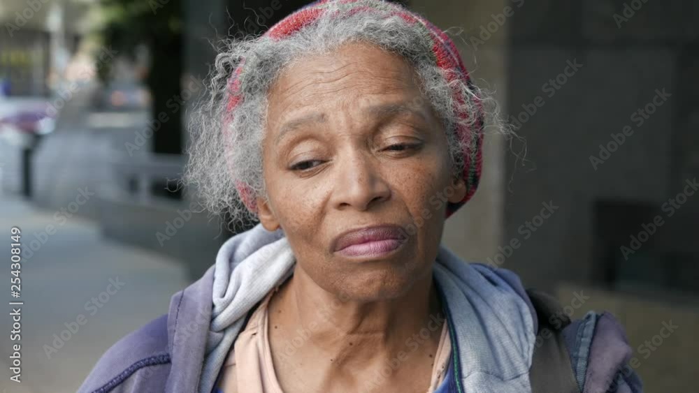 Portrait of emotional African American homeless woman looking in camera dejected