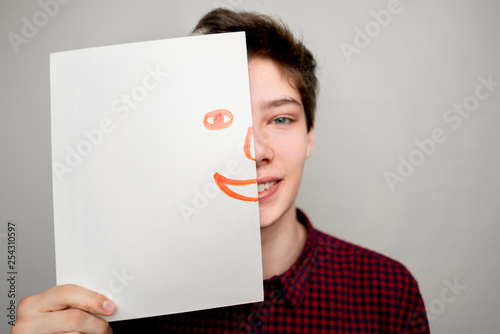 portrait of attactive man hold hand drawn emotion half face mask b photo