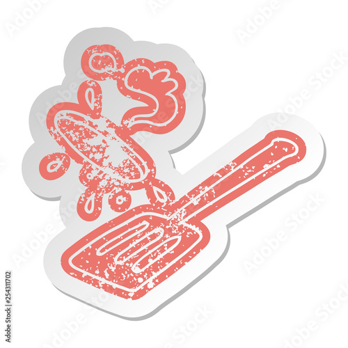 distressed old sticker of a burger being flipped