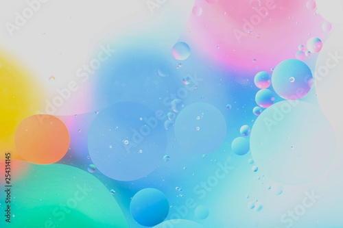 Blurred abstract background. Image of abstract blue, pink and yellow circles and drops of different sizes. Cropped shot, horizontal, blurred, free space, nobody