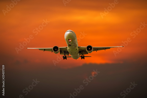 Passenger plane in flight. Aircraft fly high in the sky above the clouds during sunset on vacation during a journey . Front view of airplane.