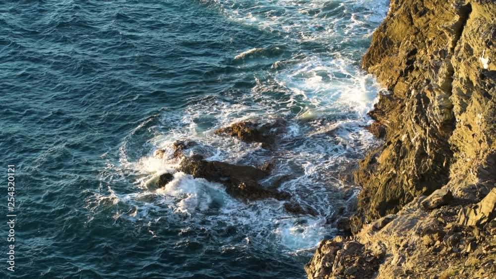 Waves crashing on reefs at the bottom of rocky cliff. Presqu'ile de Giens, France Waves crashing on reefs at the bottom of rocky cliff. Presqu'ile de Giens, France
