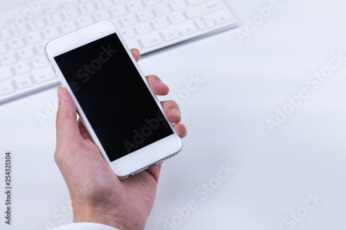 スマートフォンを持つビジネスマン　白背景　キーボード
