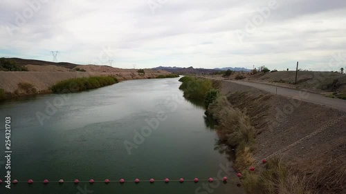 Backwards drone dolly over the all American Canal on a cloudy day.
