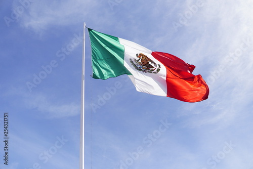 Mexico flag waving high with blue sky photo