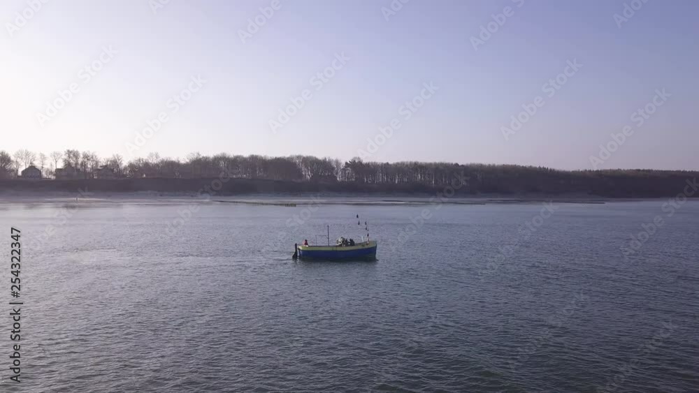 Two persons working on a fishing boat in the sea. Fishermen are catching fishes. Two persons working on a fishing boat in the sea. Fishermen are catching fishes.