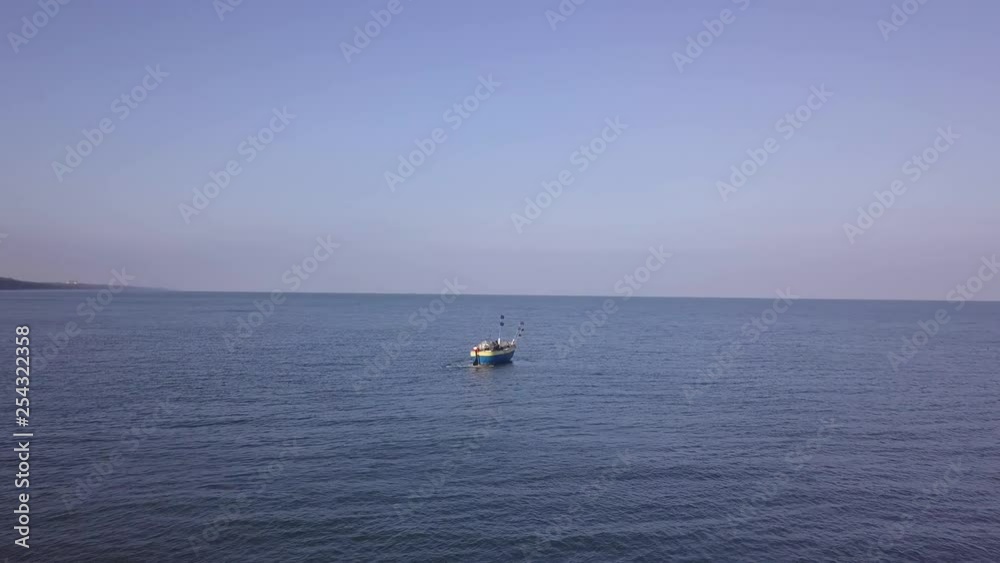 Drone follow shot of a boat on the sea cost. Old vintage wooden boat in coral sea. Drone follow shot of a boat on the sea cost. Old vintage wooden boat in coral sea.