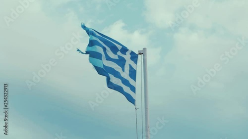 Worn Greek flag blowing in the wind overcast sky 60FPS photo