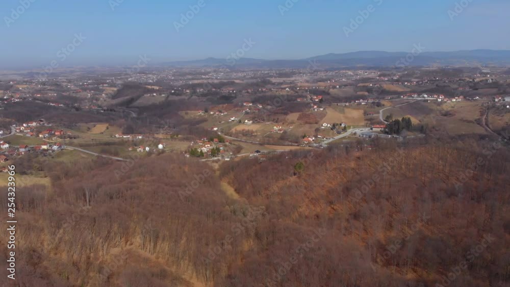 Aerial panning shot of a countryside village situated near hills during day time Aerial panning shot of a countryside village situated near hills during day time