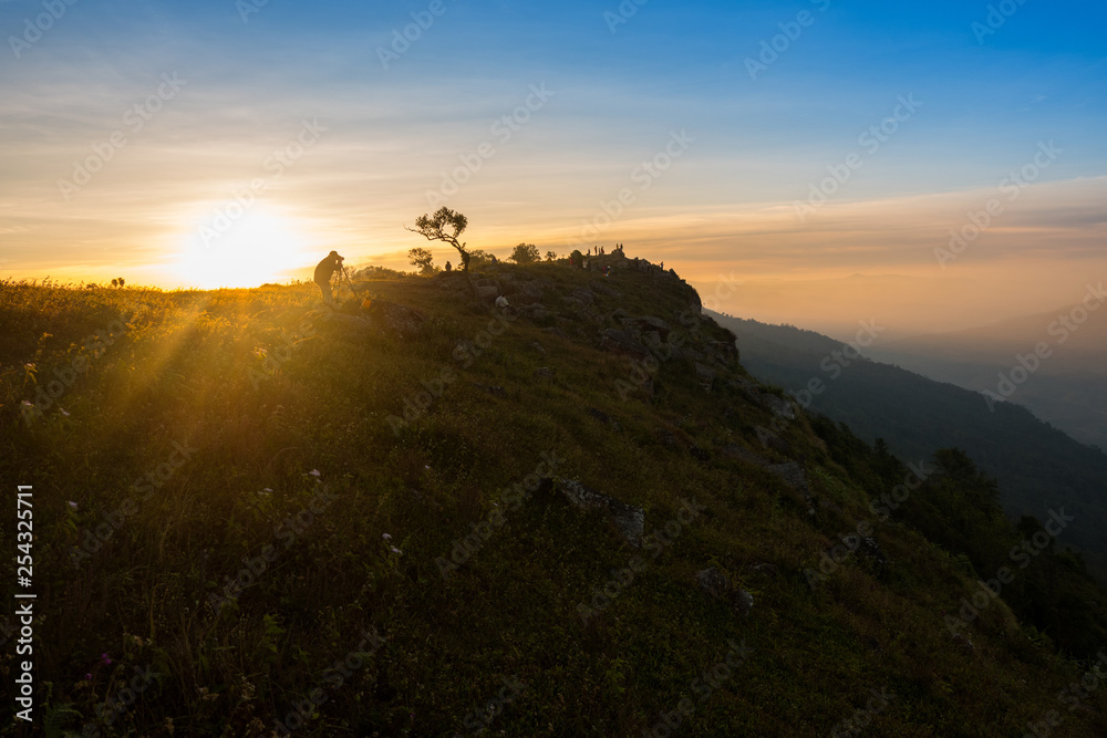 Mountaineer hiking and photographer on top hill mountains and colorful sunrise