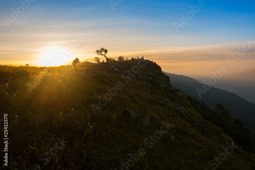 Mountaineer hiking and photographer on top hill mountains and colorful sunrise