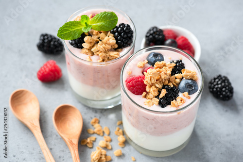 Fruit Berry Yogurt With Granola And Fresh Berry Fruits. Concrete background. Healthy eating, dieting, fitness and sporty lifestyle concept