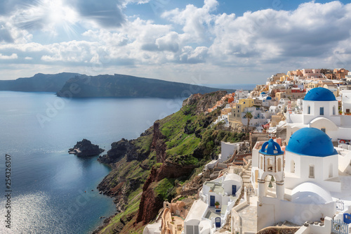 Traditional white houses and churches with blue domes over the Caldera, Santorini, Oia, Greece.