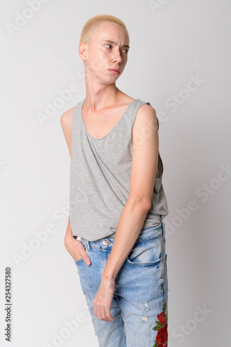 Portrait of young androgynous man thinking and looking back