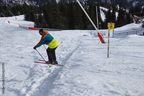 Child skier jumping on downhill in Chopok, Low Tatras, Slovakia. A boy jumping in free ride. Colorful jacket. Man in jump on ski