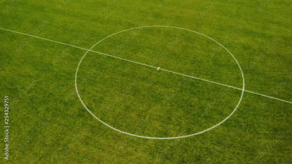 Aerial drone shot circling around center circle of football field short Aerial drone shot circling around center circle of football field short