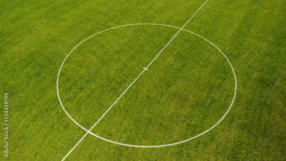 Aerial drone shot circling around center circle of football field long Aerial drone shot circling around center circle of football field long