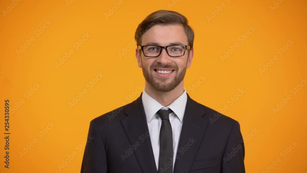 Friendly man in suit waving hand, saying hello, inviting for work, education Friendly man in suit waving hand, saying hello, inviting for work, education