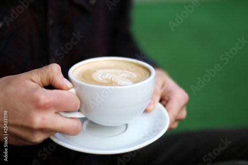 man holding a cup of coffee  cappuccino 