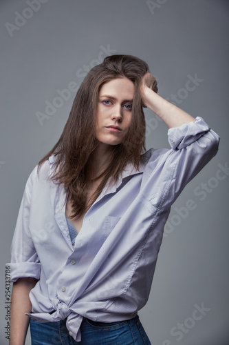 beautiful girl with blue eyes posing over gray background © Georgii