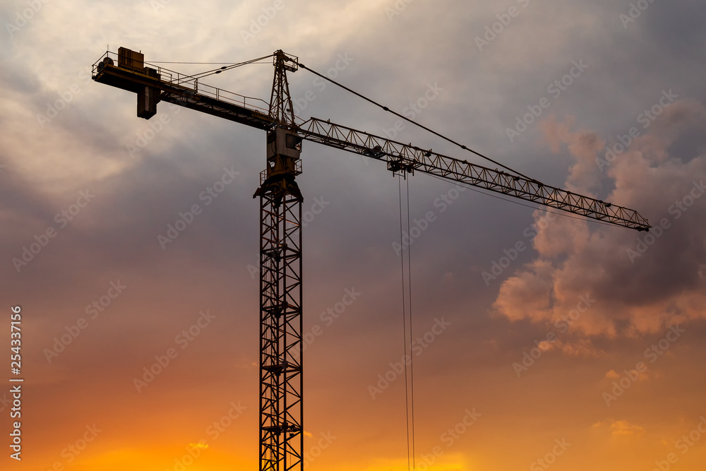 Construction crane on the background of a beautiful sky at sunset