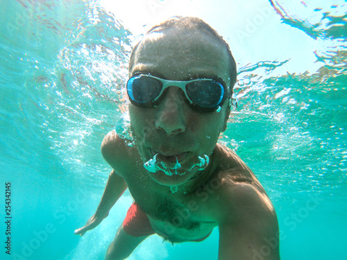 Underwater photo of active man swimming