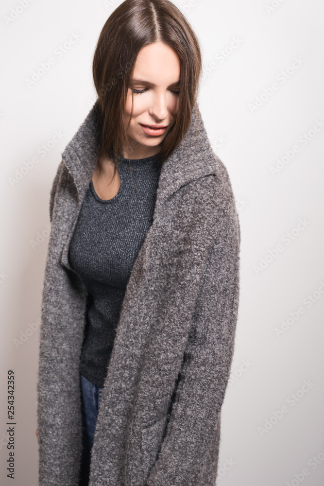 Beautiful young girl in gray coat posing in studio. Beautiful young girl in gray coat posing in studio.