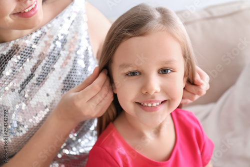 Portrait of cute little girl with mother at home