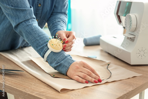 Female tailor working with sewing patterns in atelier