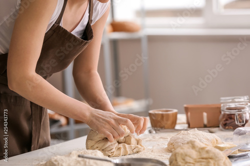 Female baker making dough in kitchen