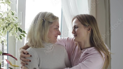 Beautiful mother and daughter hugging and talking