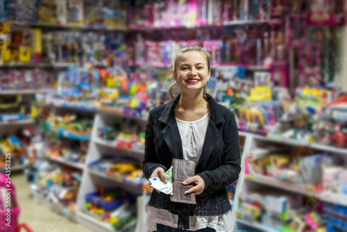 Beautiful woman with euro posing in toy shop