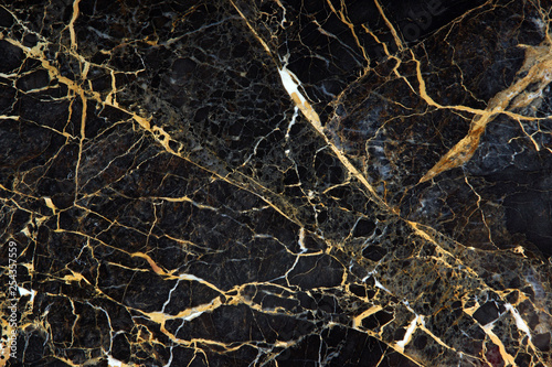 The surface of the slab of dark expensive marble with yellow and white veins is called New Portoro