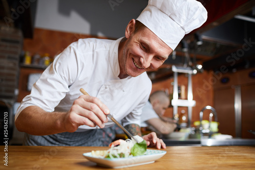Fotografija Portrait of professional chef plating Asian seafood dish in restaurant, copy spa