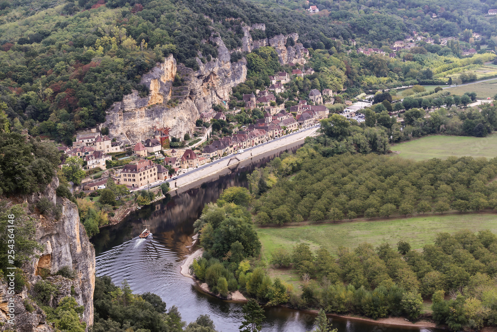 View from the top of mountain on river Dordogne, fruit gardens and town La Roque-Gageac in France.