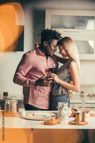 Two loving people holding glasses of wine and hugging