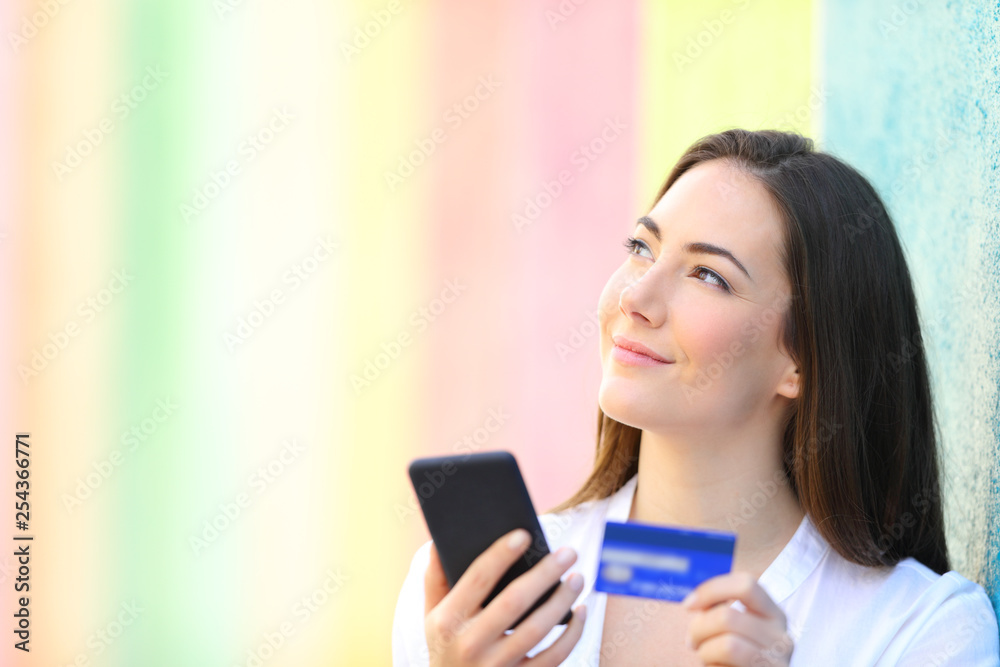 Happy online shopper thinking looking at side Happy online shopper thinking looking at side