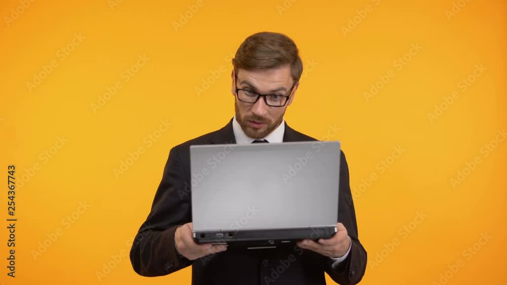 Shocked man looking with astonishment at computer, high interest rate, taxes Shocked man looking with astonishment at computer, high interest rate, taxes