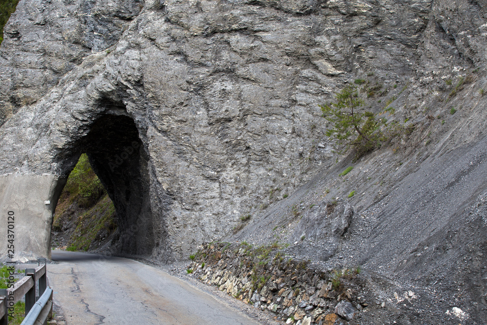 Strasse durch den Felsen. Tunnel in den Berge. Schmale und gefährliche Strasse.