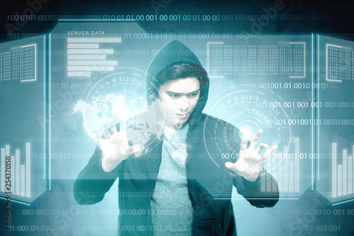 Young asian hacker in black hoodie touching virtual screen