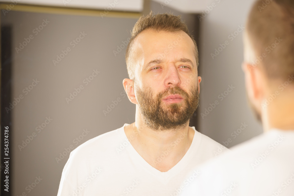 Fototapeta premium Man looking at himself in mirror