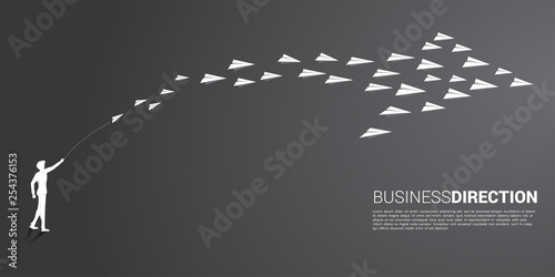 silhouette of businessman throw out white origami paper airplane is arranged in a shape of big arrow. Business Concept of company leadership.Company vision mission.