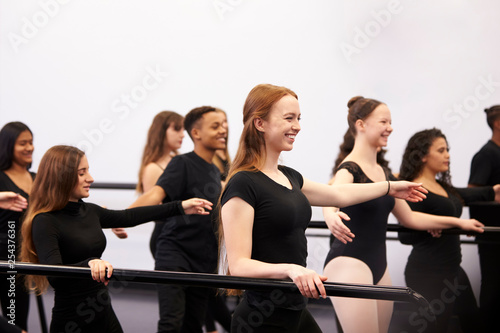 Male And Female Students At Performing Arts School Rehearsing Ballet In Dance Studio Using Barre © Monkey Business