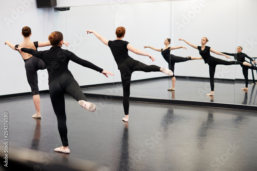 Female Students At Performing Arts School Rehearsing Ballet In Dance Studio Reflected In Mirror